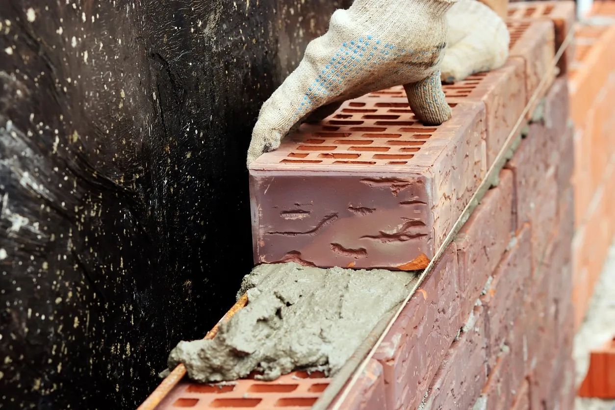 recorte mano de albañil con bloque de ladrillo